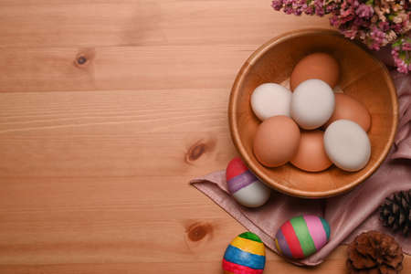 Above view young woman holding paintbrush and coloring egg. Happy Easter concept.