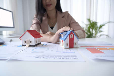 Overhead view real estate agent using calculator on white office desk. Real estate investment and insurance concept.の写真素材