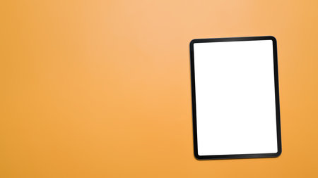 Flat lay digital tablet with blank screen on yellow background with copy space.の写真素材