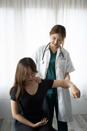 Caring female physiotherapist working with patient in clinic.  Physiotherapist Insurance concept.の写真素材