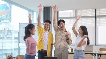 Startup business team celebrating business success or victory together in office.