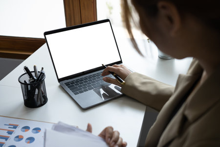 Smiling millennial female employee working with computer laptop at comfortable workplace.の写真素材