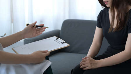 Psychologist doctor consulting in psychotherapy session or counseling diagnosis with patient.の写真素材