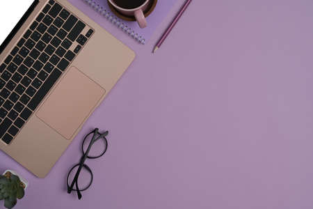 Top view laptop computer, smart phone, coffee cup and glasses on yellow background with copy space for your information content.の写真素材