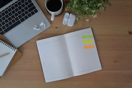 Laptop computer and office supplies on wooden background. Flat lay.