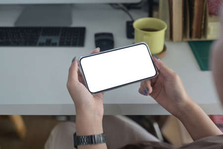 Close up view  young woman hands holding smart phone with blank screen for advertise text.