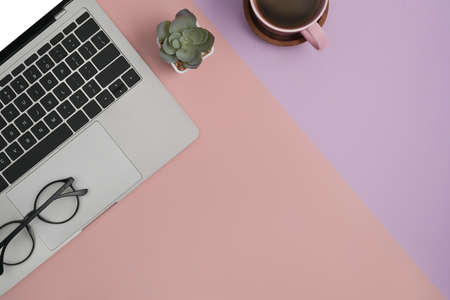 Pastel office desk with laptop computer, notebook and coffee cup. Flat lay, Top view with copy space.の写真素材
