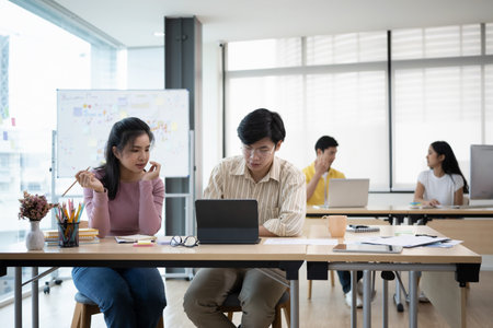 Focused start up business team working together and writing ideas on whiteboard during meeting.の写真素材