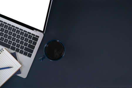 Laptop computer, cup of coffee and notebook on dark blue background. Top view, flat lay, copy space.の写真素材