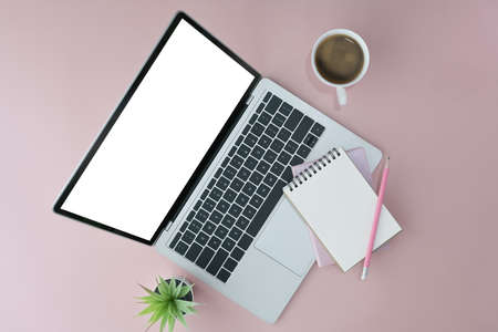 Above view computer laptop, empty notepad and coffee cup on pink background.の写真素材