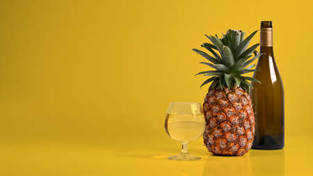 Tasty pineapple cocktail on yellow background with copy space for your text.
