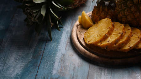 Ripe sliced pineapple on wooden background with copy space. Summer, tropical fruit concept.の写真素材