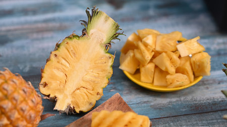 Whole and sliced juicy pineapples on wooden background with copy space. Tropical fruits, summer concept.の写真素材
