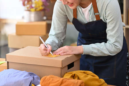 Woman online seller using digital tablet for confirming orders or taking orders from customer.の写真素材