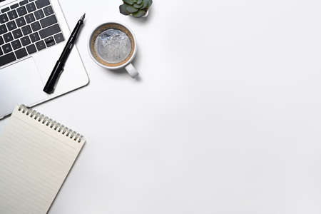 Minimal workplace with laptop computer, coffee cup, notepad and potted plant. Flat lay, Top view...