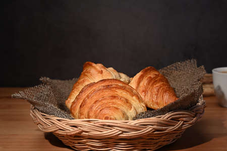 Fresh baked croissant in wicker basket. Levitation, bread bakery products cafe concept.の写真素材