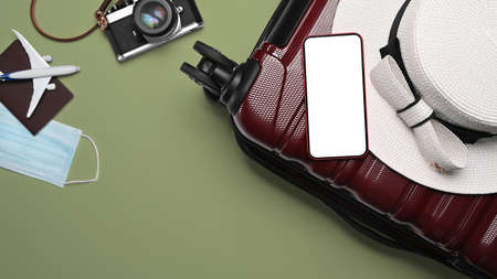 Top view a suitcase, smart phone, sunglasses, camera and passport on green background for summer holidays.の写真素材