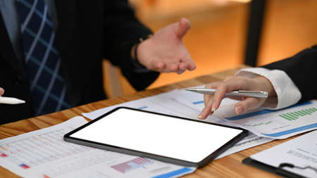 Cropped shot two professional businesspeople analyzing online information in digital table together.の写真素材