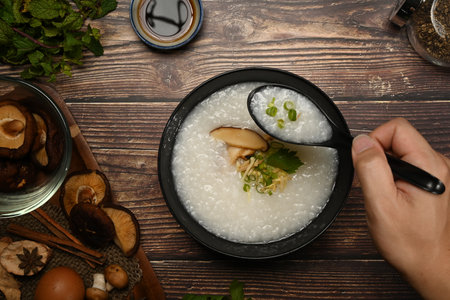 Testy rice porridge with soft boiled egg, shiitake mushroom, slice ginger and slice scallion for...
