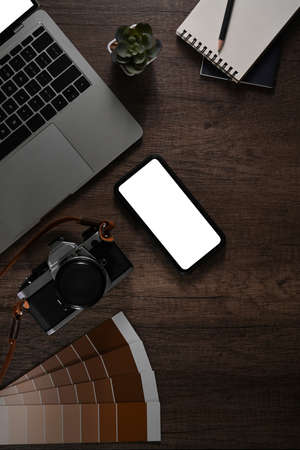 Creative designer workspace with smart phone, laptop, camera and color swatches. Top view, flat lay.の写真素材