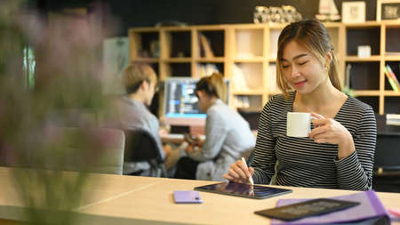 Software engineers team leader using digital tablet and young IT development team working in...