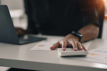 Cropped view of professional businessman using laptop and preparing annual financial report at office desk.の写真素材