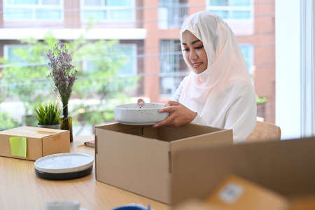 Asian muslim woman preparing product for shipping to customers. E-commerce concept.の写真素材