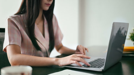 Cropped shot of working woman typing business email, searching information on laptop computer.の写真素材