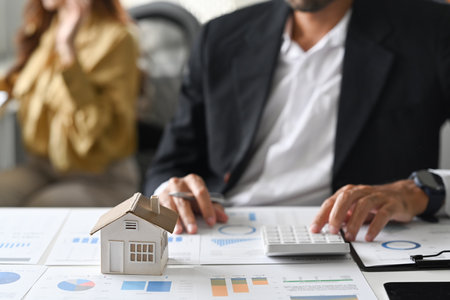 Young man investors using calculator for calculating loan of finance and planning for real estate investment.の写真素材