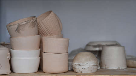 Handmade ceramic crockery on wooden shelf in creative studio.の写真素材