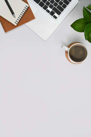 Above view white office desk with laptop, notepad, houseplant and coffee cup. Top view with copy space.の写真素材