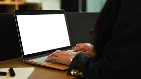 Close up view businesswoman hands typing on laptop computer, working at modern office.の写真素材