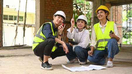 Civil engineers team wearing safety helmets and vests inspecting construction site. Industry, Engineer, construction concept.の写真素材