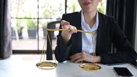 Cropped imaged of attorney or lawyers holding brass scale. Lawyer, justice and law and attorney concept.の写真素材