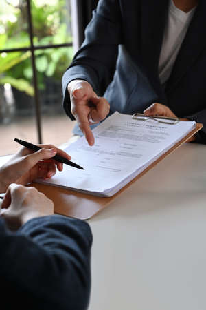 Businessman discussing contract document or investment plan with female lawyer or financial advisor.の写真素材