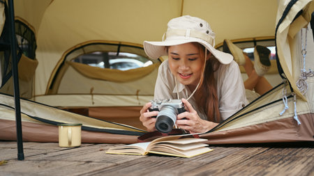 Happy young asian female traveler camping in nature park on beautiful day. Travel, adventure and vacation concept.の写真素材