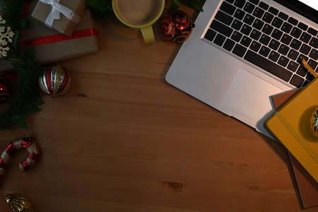 Laptop, Christmas decoration and supplies and cup of coffee on wooden table. Top view with copy space for, Business Holidays Concept.の写真素材