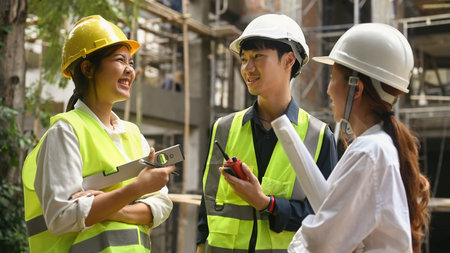 Team of civil engineer wearing safety helmet and yellow vests planning development details at...