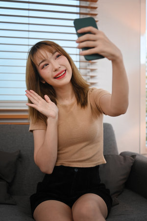 Pretty young woman enjoy chatting online or making video call on her smart phone.の写真素材