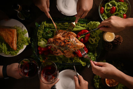 From above view group of friends or family enjoy eating roast turkey, Thanksgiving meal together. Celebration, holidays and Christmas concept.の写真素材
