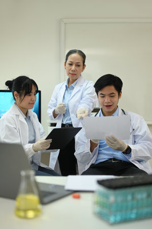 Experienced senior woman scientist and young researcher analyzing test samples, discussing about new...