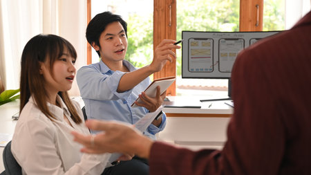 Young creative team brainstorming, working together on mobile application software design project at...