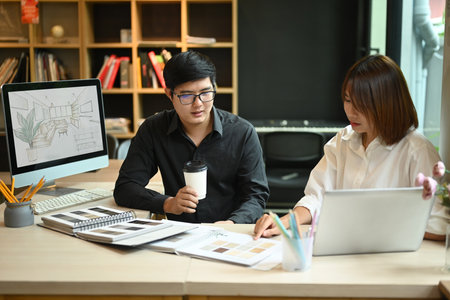 Team of interior designers sharing idea, selecting colors for building and planning construction project together at office.の写真素材
