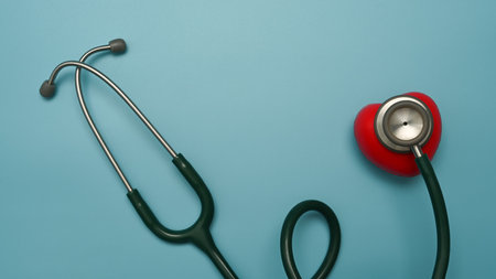 Stethoscope and red heart on blue background. Healthcare, cardiology and life insurance concept.の写真素材