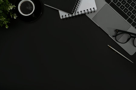 Laptop computer, coffee cup and potted plant on black background. Copy space for your text.の写真素材