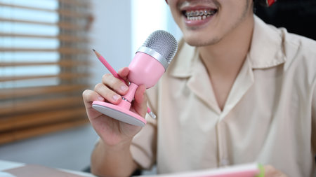 Image of radio host using microphone and laptop to recording podcast in home studio. Radio, podcasts and technology concept.の写真素材