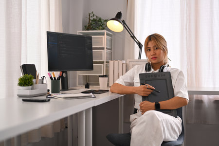 Young female programmer working with coded data on desktop computer in bright modern office.