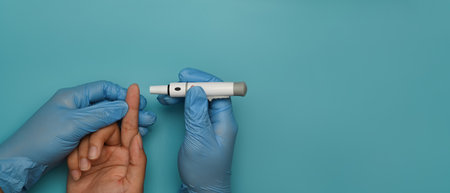Nurse taking blood sample with lancet pen of diabetic patient for checking blood sugar level. Diabetes and health care concept.の写真素材