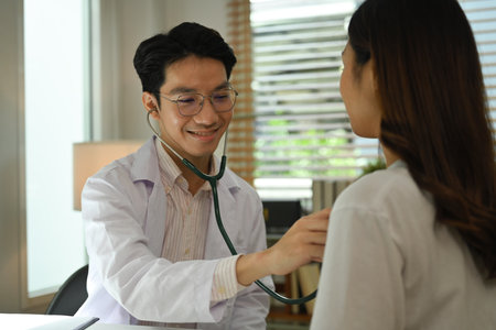 Doctor examining, checking heart lungs of patient with stethoscope. Medical care, healthcare and people concept.の写真素材