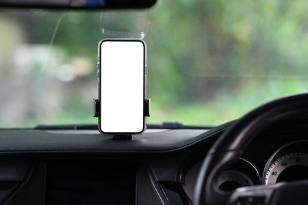 Smart phone with blank screen in car windshield holder. White empty screen for your advertise design.の写真素材